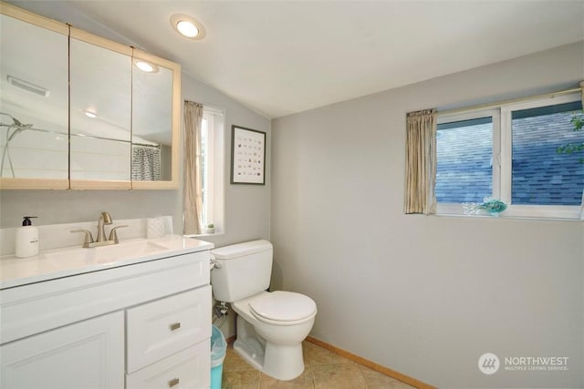 bathroom featuring toilet, vaulted ceiling, vanity, a wealth of natural light, and tile patterned flooring