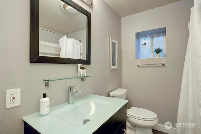 bathroom featuring vanity, toilet, and walk in shower