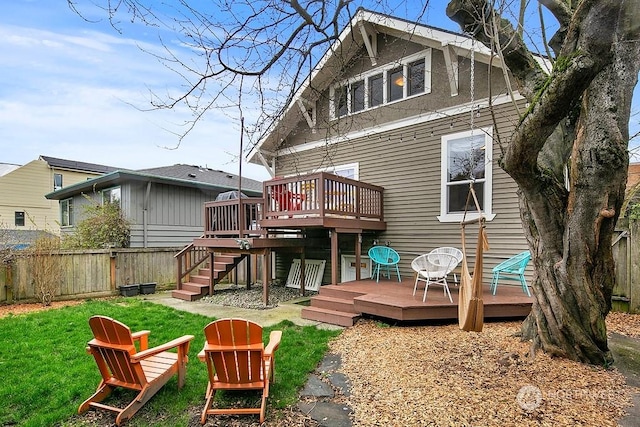 back of house featuring a wooden deck and a lawn