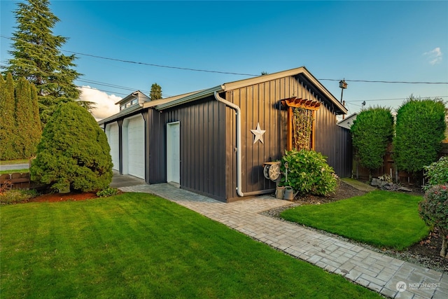 view of outdoor structure with a yard and a garage