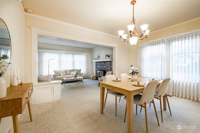 carpeted dining space featuring ornamental molding, an inviting chandelier, and a fireplace