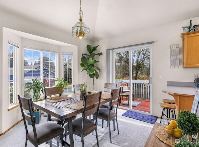 dining area featuring light carpet, a notable chandelier, and a wealth of natural light