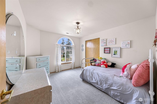 bedroom featuring light colored carpet and a notable chandelier