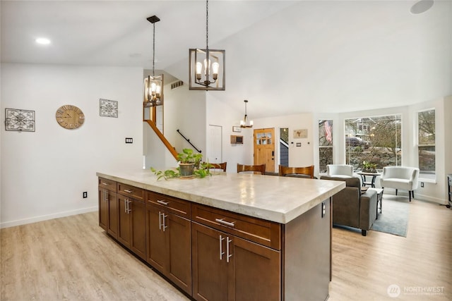 kitchen with a chandelier, light wood-style flooring, pendant lighting, and light countertops