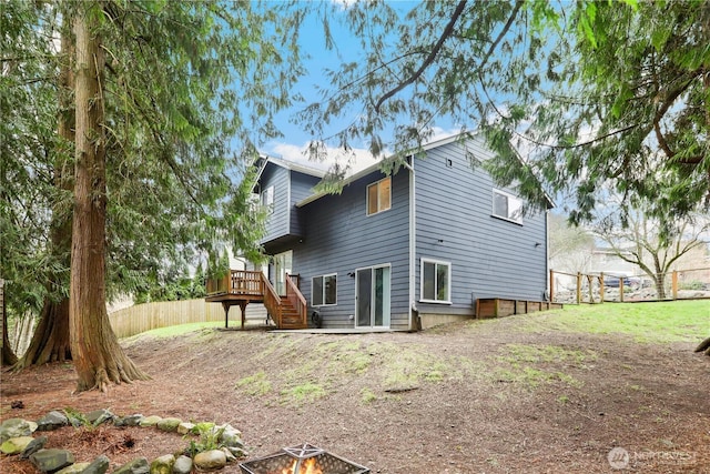 rear view of property with stairway, a deck, and fence