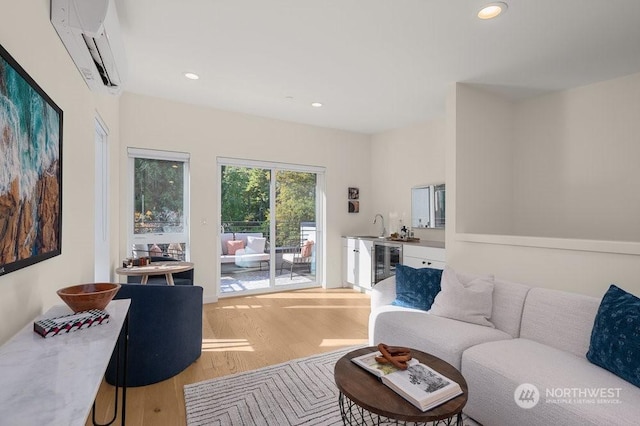 living room with wine cooler, light hardwood / wood-style flooring, a wall mounted AC, and indoor bar