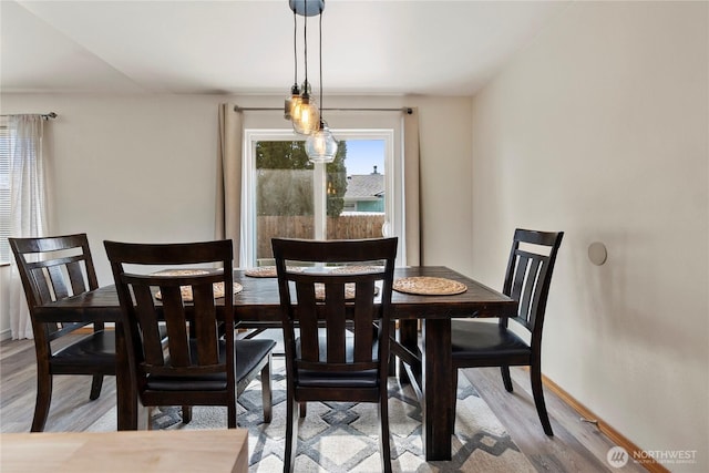 dining area with baseboards and light wood-style floors