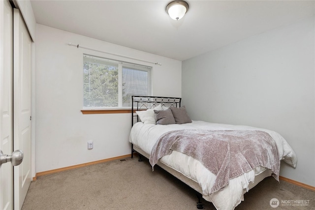 bedroom with a closet, baseboards, and carpet