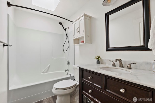 bathroom featuring vanity, wood finished floors,  shower combination, a skylight, and toilet