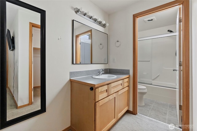 bathroom featuring shower / bath combination with glass door, toilet, and vanity