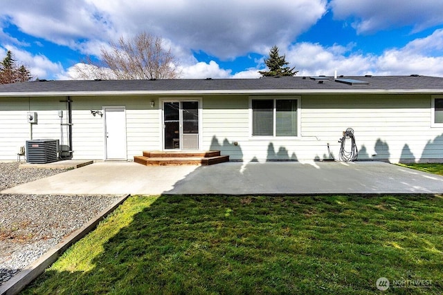 rear view of house with cooling unit, a lawn, and a patio area