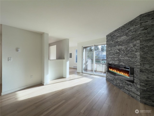 unfurnished living room with light wood-type flooring and a fireplace