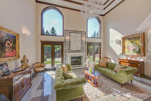 living room featuring crown molding, a fireplace, french doors, and a high ceiling