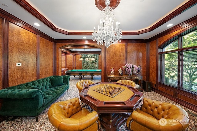 rec room with wood walls, pool table, a notable chandelier, and a tray ceiling