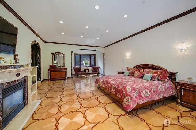 bedroom featuring ornamental molding, a premium fireplace, and light parquet flooring