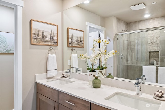 bathroom with vanity and a shower with shower door