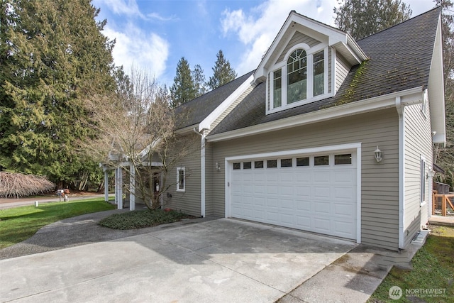 view of front facade with a garage, a shingled roof, and concrete driveway