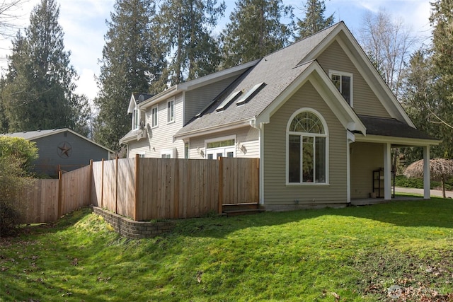 back of property featuring a lawn and fence