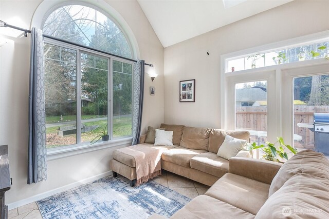 tiled living room with vaulted ceiling and baseboards