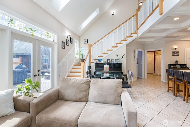 living area featuring light tile patterned flooring, a skylight, a towering ceiling, french doors, and stairway