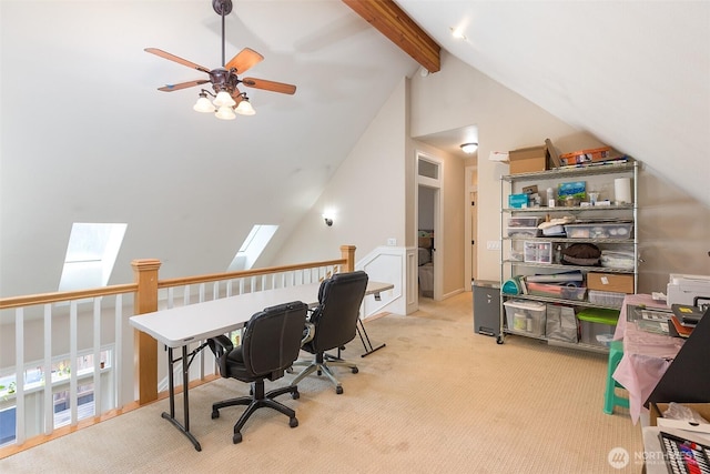 home office with high vaulted ceiling, a skylight, beam ceiling, and light colored carpet