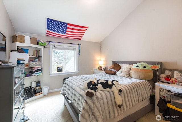 carpeted bedroom with vaulted ceiling and baseboards