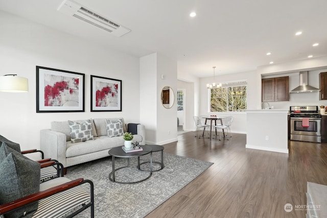 living room with dark hardwood / wood-style floors and a notable chandelier