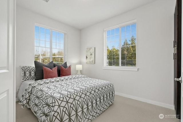 carpeted bedroom featuring multiple windows