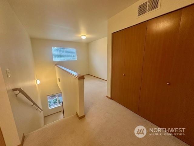 hall featuring light colored carpet