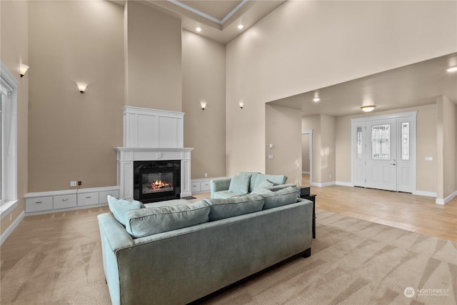 living room featuring a high ceiling and light colored carpet