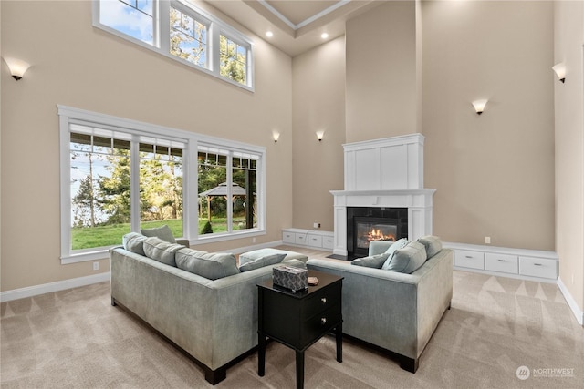 carpeted living room featuring plenty of natural light and a towering ceiling