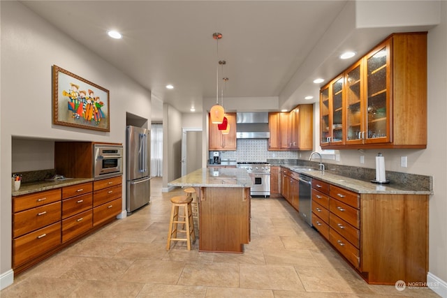 kitchen featuring pendant lighting, sink, a center island, high end appliances, and wall chimney exhaust hood