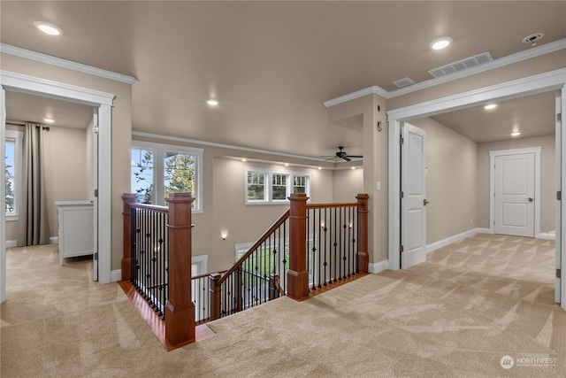 corridor with crown molding and light carpet