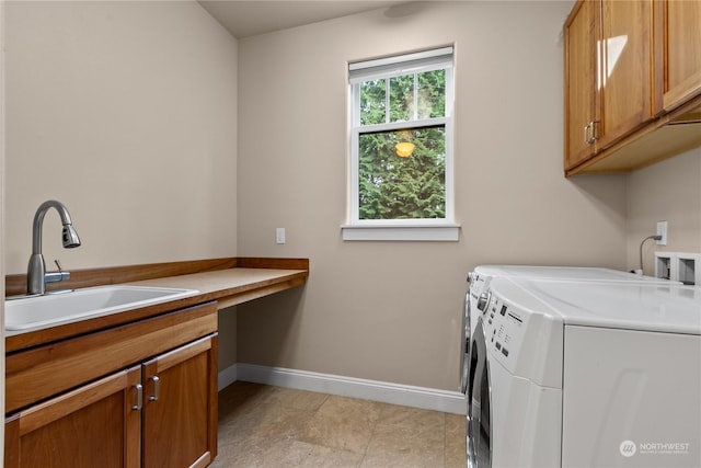 clothes washing area with cabinets, sink, washing machine and dryer, and light tile patterned floors