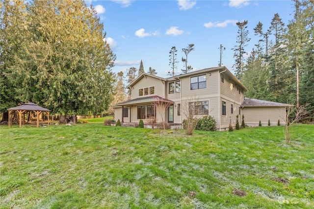 back of house with a gazebo and a yard