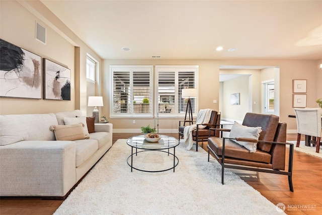 living room with baseboards, visible vents, wood finished floors, and recessed lighting