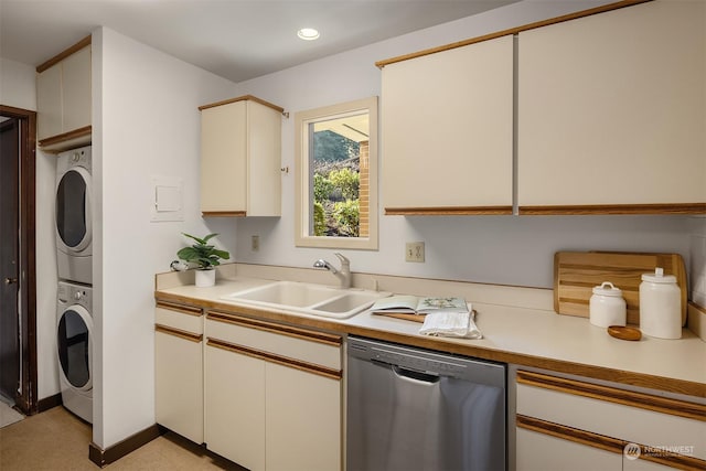 kitchen with stacked washer / dryer, dishwasher, sink, and white cabinets