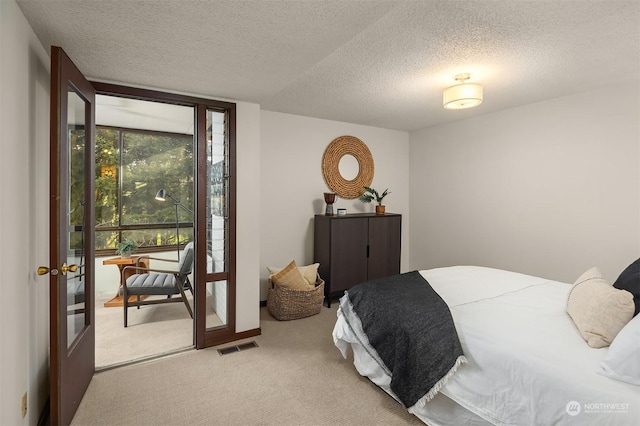 bedroom featuring french doors, light carpet, and a textured ceiling