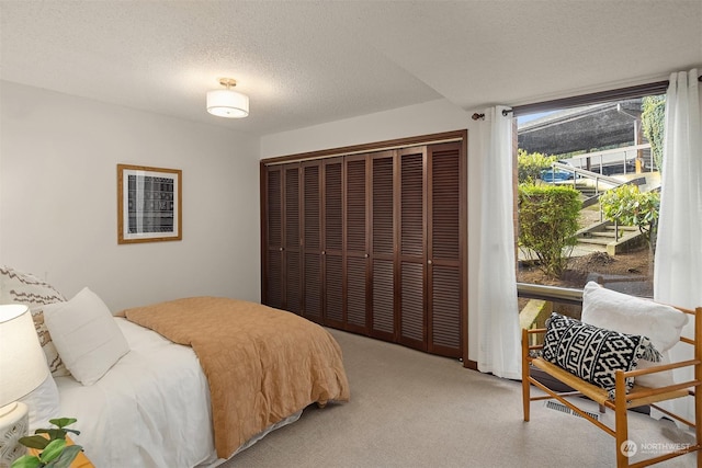 bedroom featuring a closet, a textured ceiling, and carpet flooring