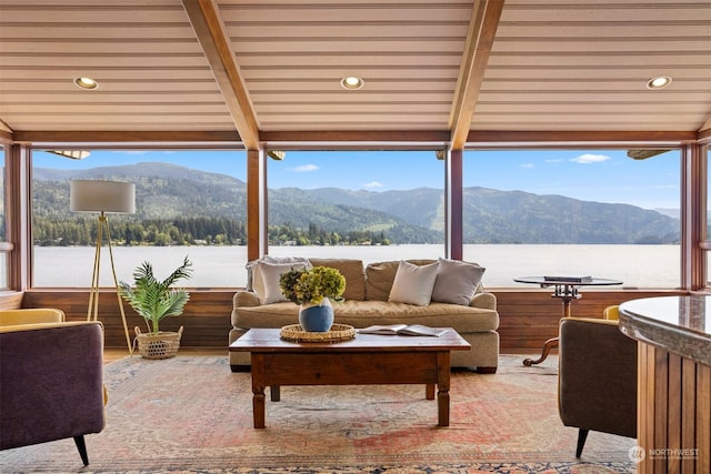 sunroom featuring beamed ceiling and a water and mountain view