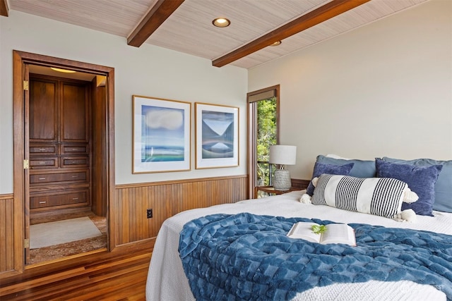 bedroom featuring dark hardwood / wood-style flooring, wooden walls, wooden ceiling, and beamed ceiling