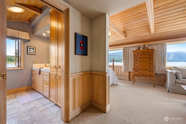 interior space with a mountain view, lofted ceiling with beams, and wooden ceiling