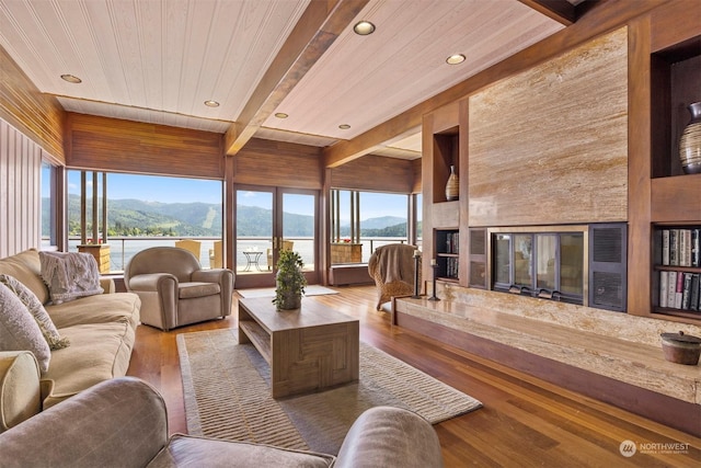 living room featuring beamed ceiling, wood ceiling, hardwood / wood-style floors, and a water and mountain view