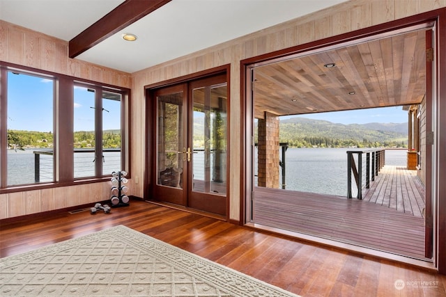 entryway featuring hardwood / wood-style floors, a water and mountain view, beamed ceiling, and a healthy amount of sunlight