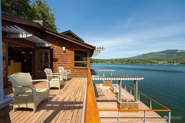 dock area featuring a deck with water view and a pergola