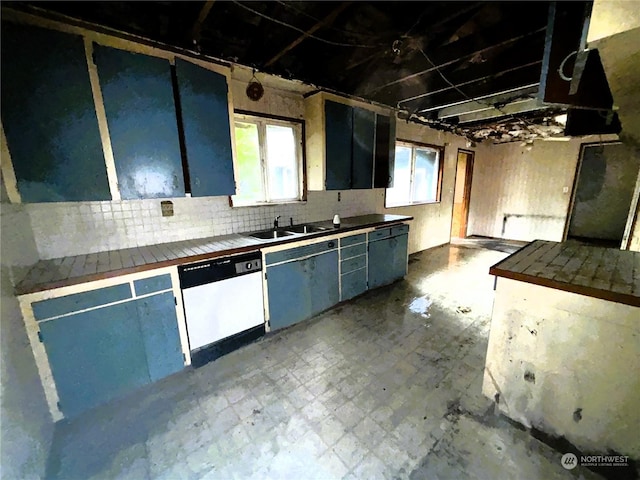 kitchen with white dishwasher, sink, backsplash, and tile counters