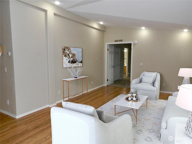 living room with vaulted ceiling and hardwood / wood-style floors