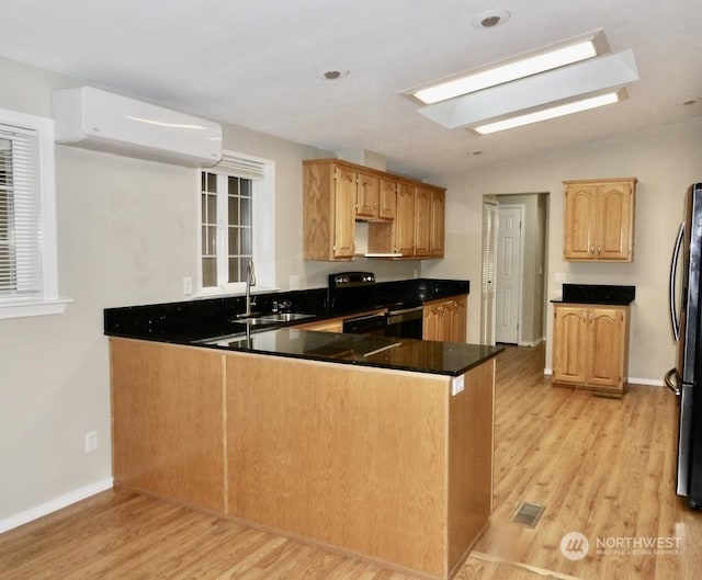 kitchen featuring vaulted ceiling, an AC wall unit, sink, stove, and kitchen peninsula