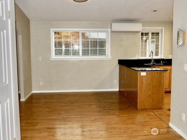 kitchen with hardwood / wood-style flooring, sink, and a wall mounted air conditioner