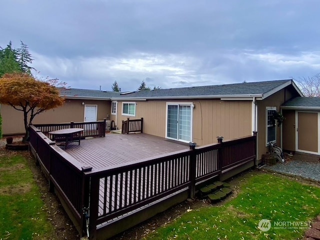 rear view of house with a wooden deck and a yard